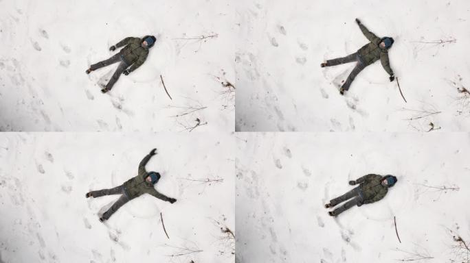 一个喜欢在新鲜雪中制作雪天使的孩子的无人机鸟瞰图