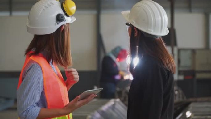 两名亚洲女性建筑工程师使用平板电脑，建筑概念在车间检查工作。