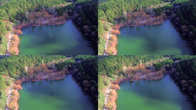 色彩缤纷的森林之间的黑色湖泊的惊人对比和景色。绿色山脉，树木，蓝天反射和土耳其伊兹密尔的Karago