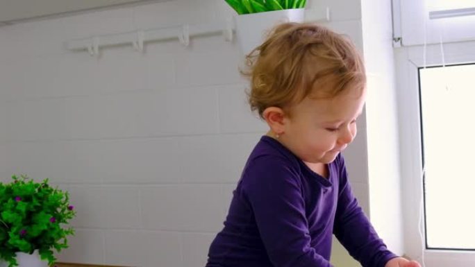 婴儿在厨房里喝一杯水。选择性聚焦。孩子。