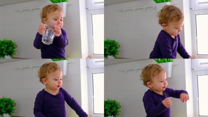 婴儿在厨房里喝一杯水。选择性聚焦。孩子。