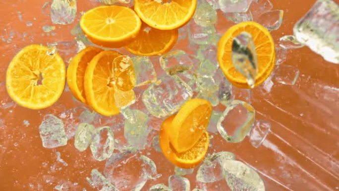 新鲜的橙色水果，冰块和滴多汁或酒精饮料或能量饮料或摇动苏打汽水飞溅倒入超级慢动作1000fps。冷橙