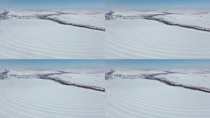 田地上冰雪表面曲线的航拍镜头，融化作业