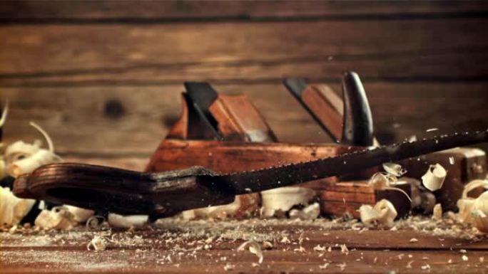 锯子落在木屑桌上。拍摄的是每秒1000帧的慢动作。