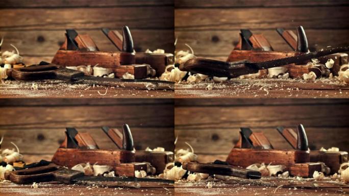 锯子落在木屑桌上。拍摄的是每秒1000帧的慢动作。