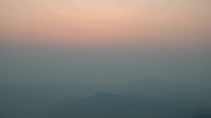 宁静的日出场景，天空模糊，山脉轮廓模糊，延时拍摄