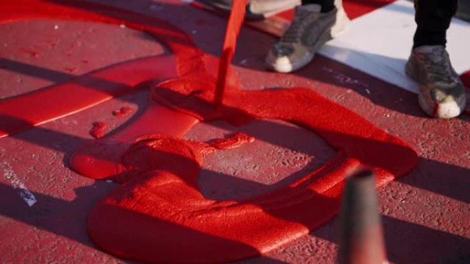 工人使用红色热塑性材料。骑自行车。工人将自行车道涂成红色和白色。