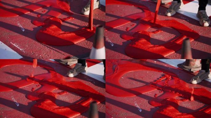 工人使用红色热塑性材料。骑自行车。工人将自行车道涂成红色和白色。