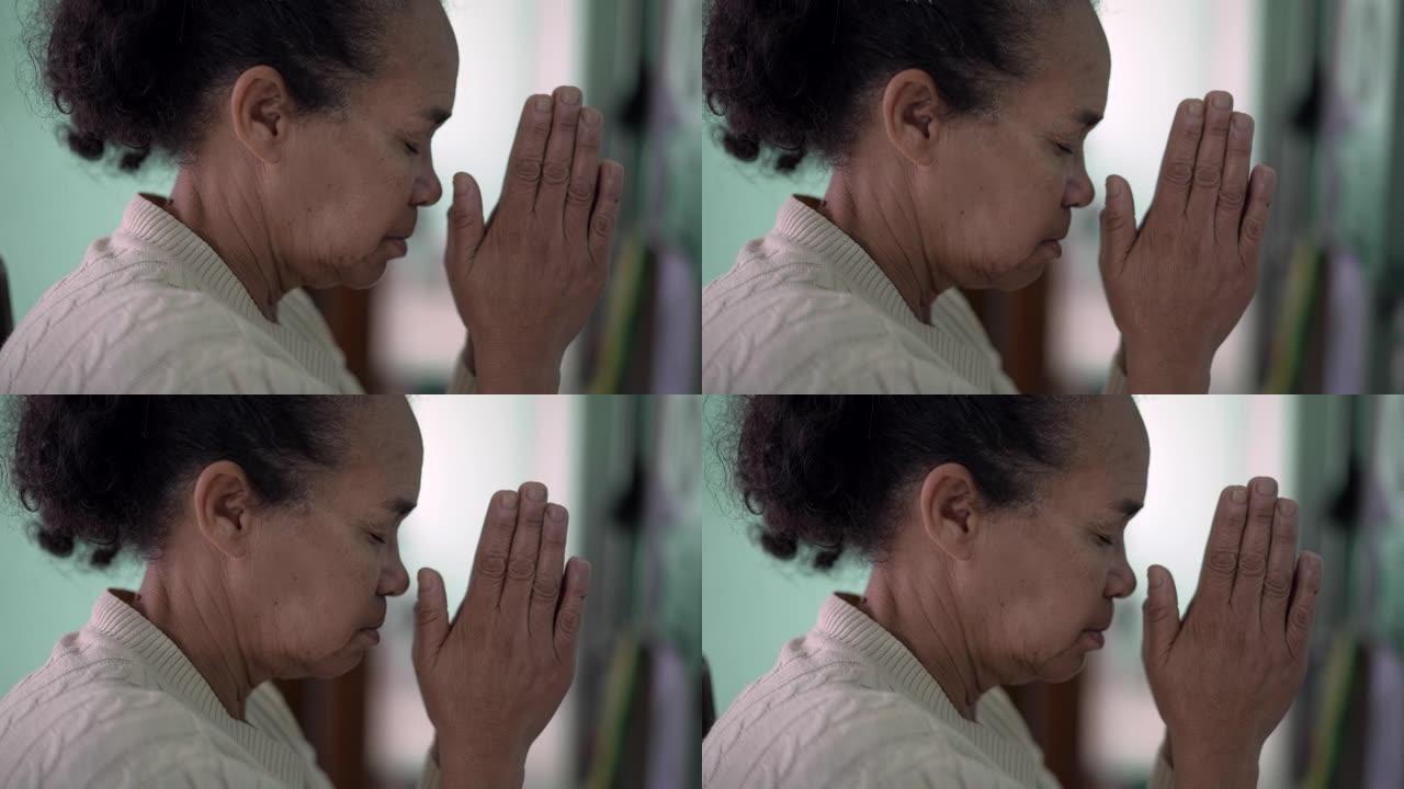 一位年长的非洲妇女祈祷有希望。一个有信仰的忠实资深黑人拉丁人