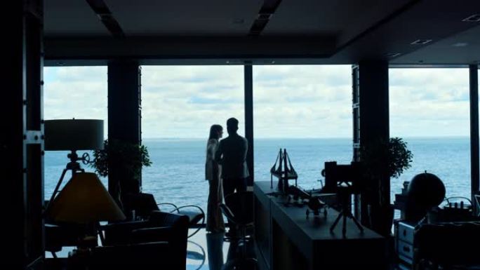 同事剪影在全景海洋窗讨论项目。奢华生活