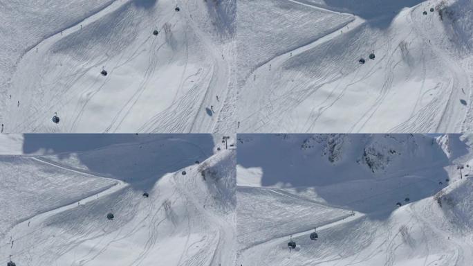 鸟瞰图人们在山谷度假胜地的轨道上骑滑雪板，索道风景