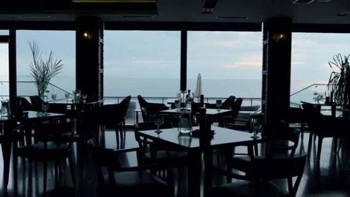 餐厅令人惊叹的全景海景。舒适酒店咖啡厅的夏日夜晚