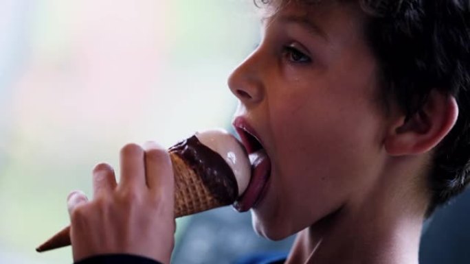 孩子吃巧克力冰淇淋一个年轻的少年男孩吃冰淇淋