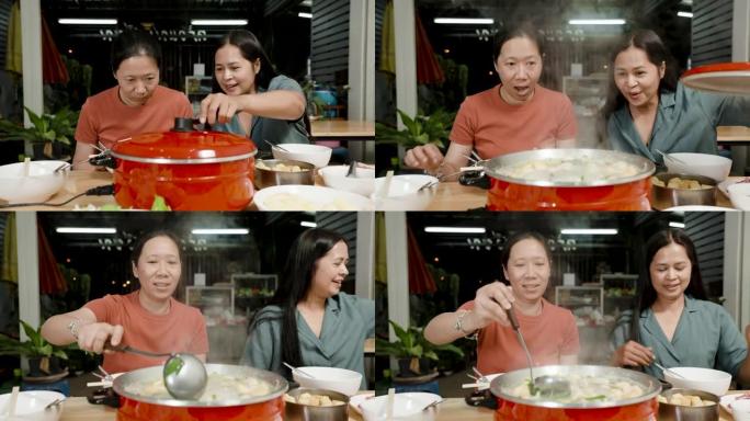 4k慢动作，一位穿着棕色和绿色衬衫的亚洲女性最好的朋友对即将煮熟并准备食用的红色锅中的sukiyak