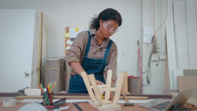 美丽的女人在木片上工作，用铅笔在木头上测量和标记。