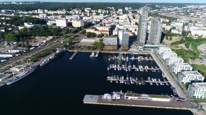 在一个现代化的海滨城市中，满是白色游艇和帆船的港口鸟瞰图。在夏天阳光明媚的日子里，有小船的码头。现代