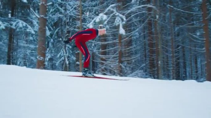 越野滑雪。穿着红色滑雪服的年轻男子在冬季森林滑雪