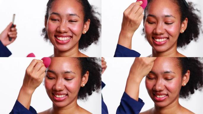 化妆师化妆非洲女性。肖像非裔美国女孩，干净健康的皮肤和非洲发型微笑孤立在白色工作室背景。