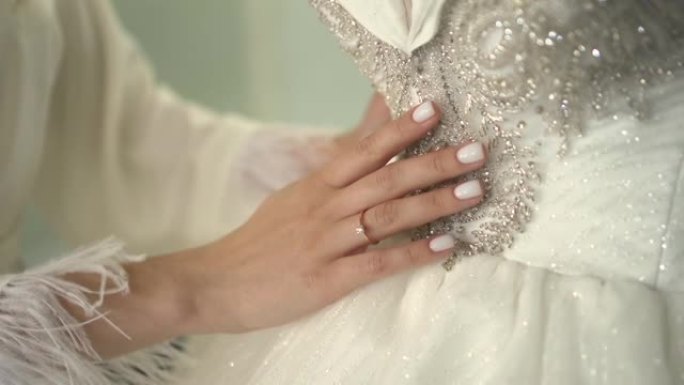 新娘用手抚摸婚纱