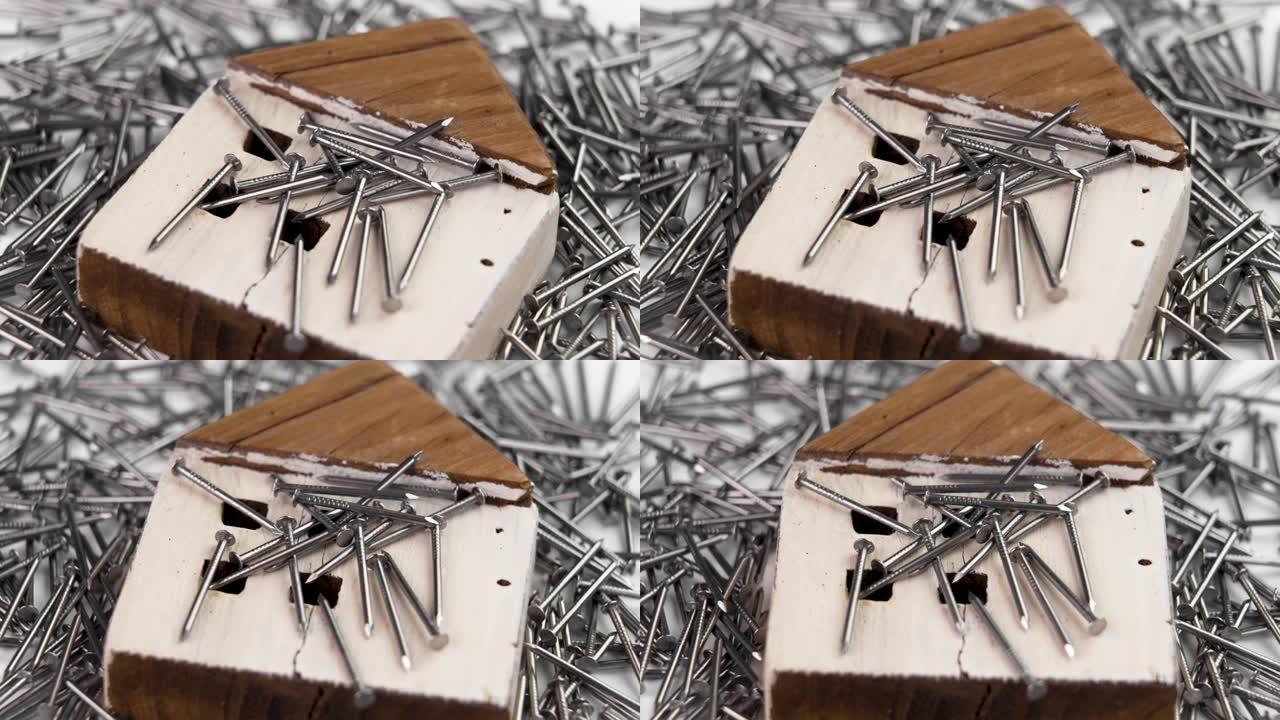 一堆金属钉中的住宅建筑的木制模型