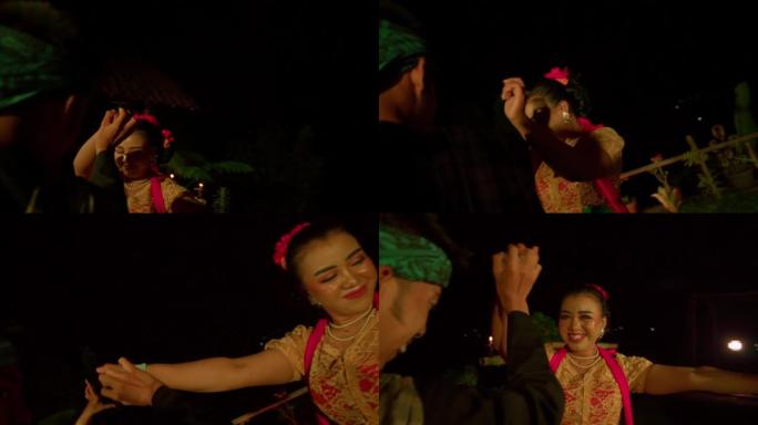 巴厘岛妇女跳舞庆祝仪式，而一个男人在舞台上的舞者之间浪费金钱