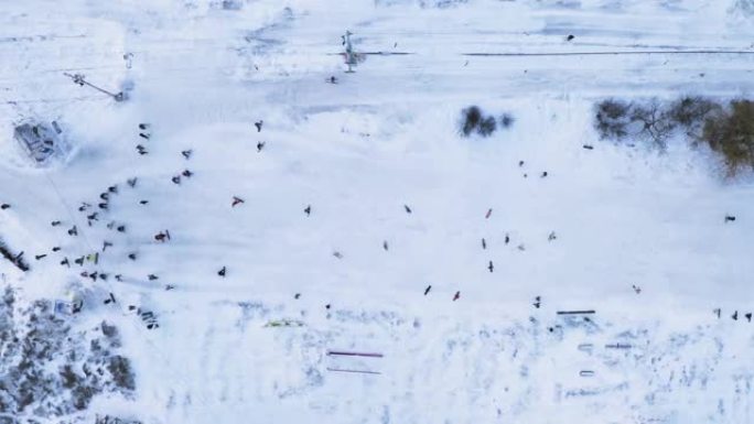 许多滑雪板运动员在周末用滑雪缆车在雪坡上滑雪-俯视无人机拍摄。