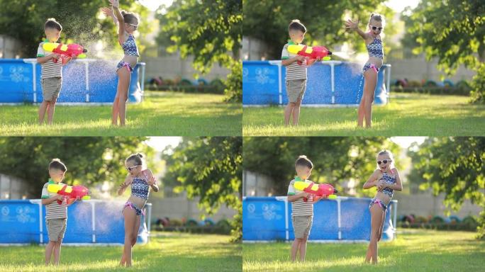 小男孩正在给她姐姐泼水。快乐快乐的孩子在花园里玩水枪的慢动作视频。
