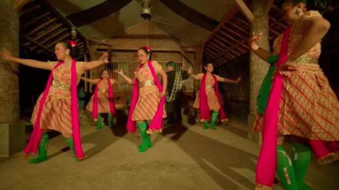 爪哇妇女在传统舞蹈节内穿着橙色连衣裙和绿色围巾一起跳舞庆祝新年