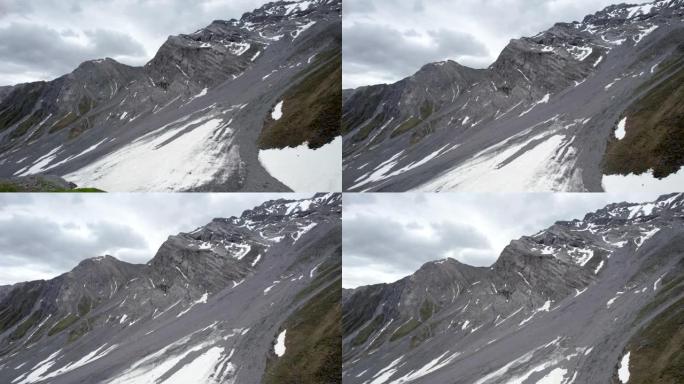 空中无人机镜头在戏剧性的锯齿状山坡中缓慢上升，向积雪覆盖的山脊望去。瑞士达沃斯。