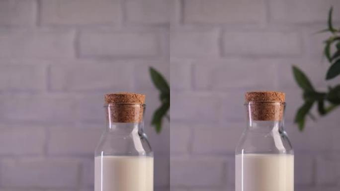 白色厨房桌子上放着牛奶的玻璃瓶，旁边放着椰子。
