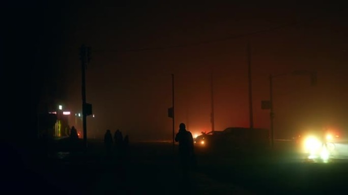 晚上，市民在街上的黑暗中行走。停电造成的完全停电。运输聚光灯是户外唯一的光源。