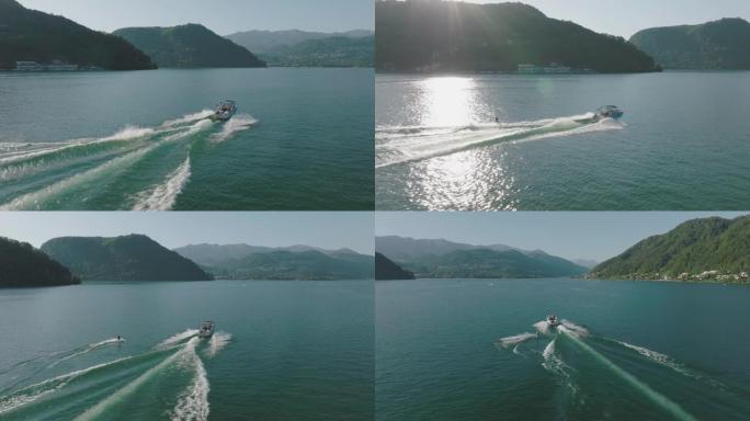 在原始平静的湖上，由摩托艇拉动的男子滑水的空中无人机拍摄