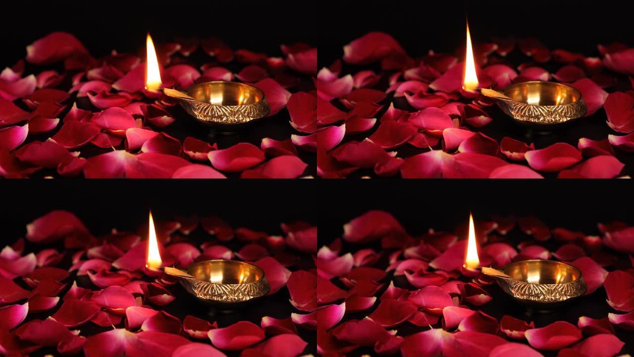 装饰Diya灯。油灯上燃烧的玫瑰花瓣装饰-排灯节。装饰玫瑰花瓣与普嘉迪亚点燃明亮的火焰。