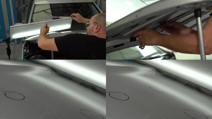汽车修理厂冰雹后修理发动机罩表面车身凹痕的过程。带技术人员的视频，配有无油漆凹痕修复工具。