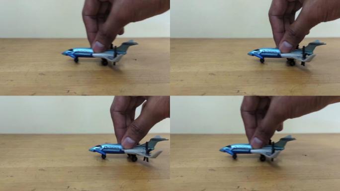 一个玩飞机玩具的男性手的特写镜头