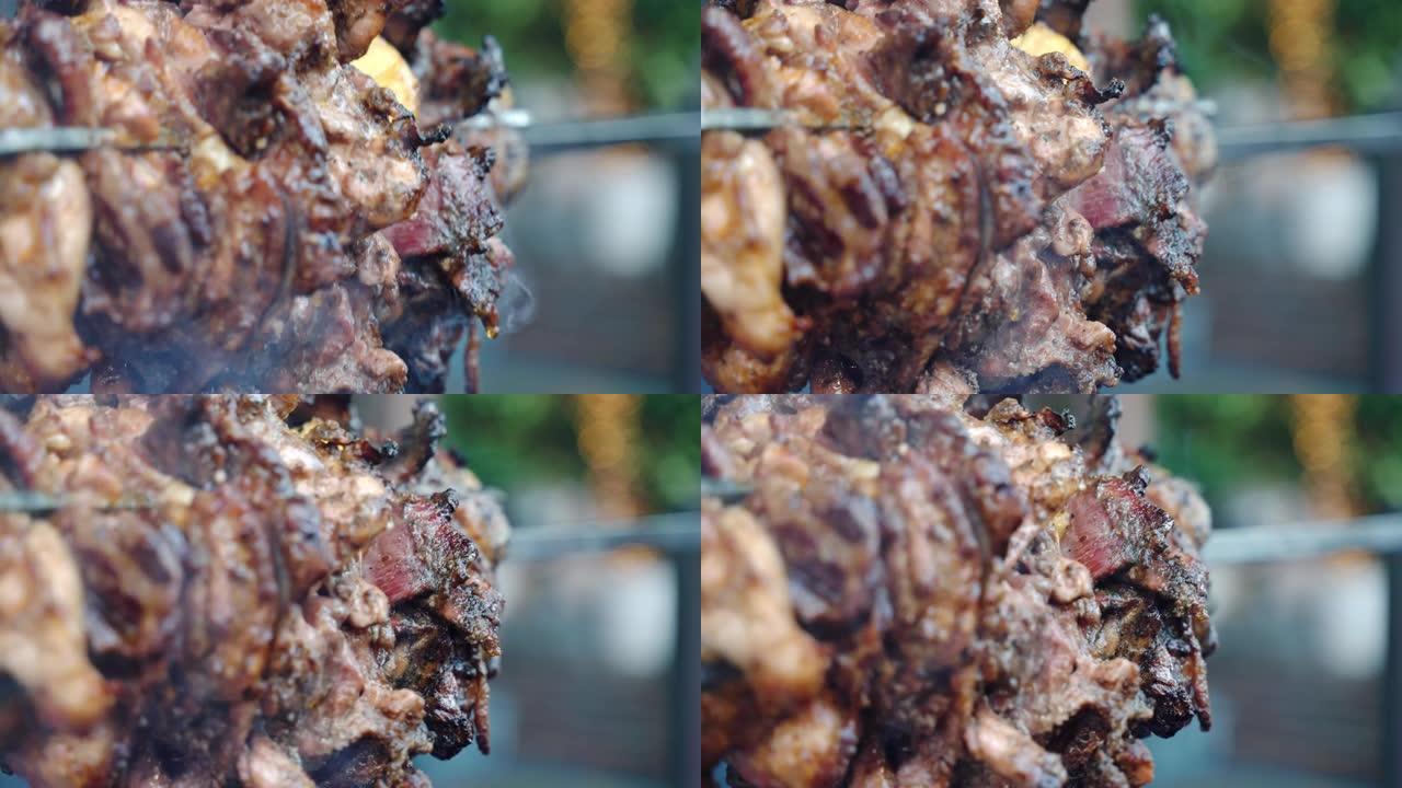 惊人的特写镜头烤肉串滴脂肪和脆皮，美味的自制腌制里脊肉在燃烧的火上旋转和热的炭，肉吐在火上吸烟。在钢