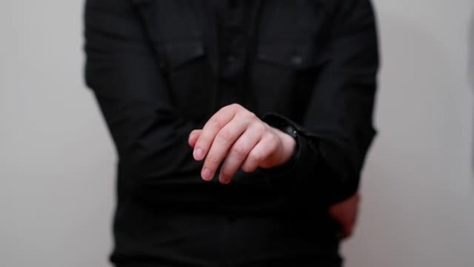 穿着黑色衬衫的男人用手做手势，好像他在使用数字触摸屏，白色背景