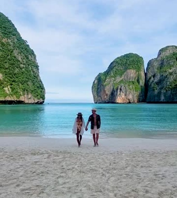 清晨，男女夫妇在海滩上散步，泰国马雅海滩