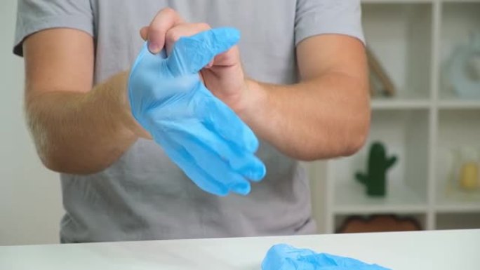 男人们戴着医用蓝色手套的手特写。这个男人戴着蓝色丁腈手套。