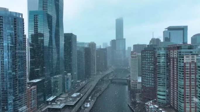 无人机鸟瞰图飞越芝加哥河，向后拉向密歇根湖，阴天冬天下雪