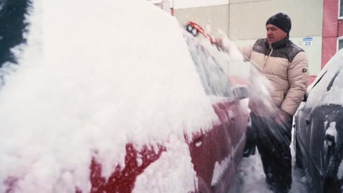 一名男子用刷子清洁一辆冰雪覆盖的汽车。
