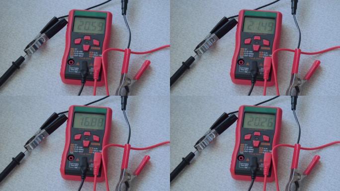 数字屏幕上电压读数不断变化的电子测试仪。