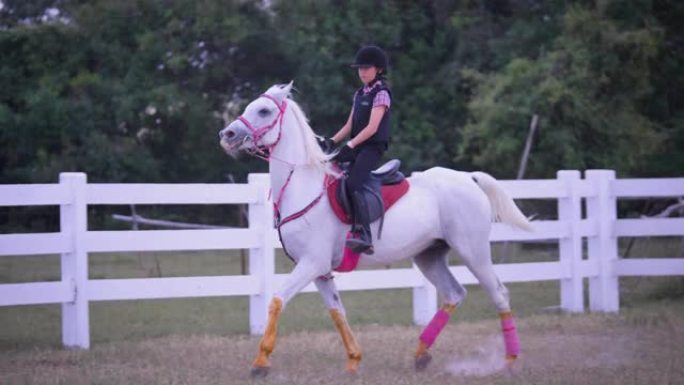 年轻的亚洲女孩喜欢在农场骑马，女孩在牧场骑马训练