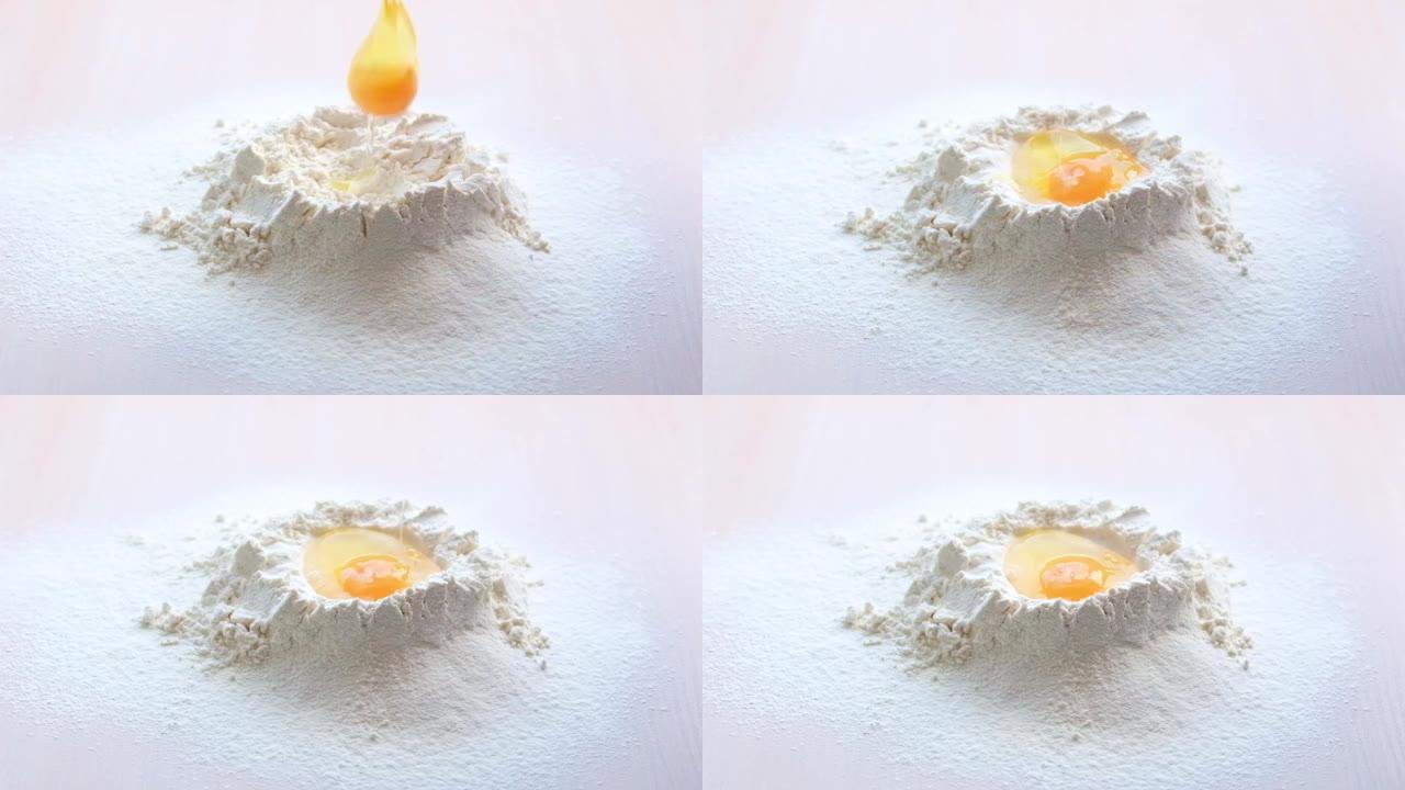 鸡蛋落入面粉的慢动作。食物镜头。鸡蛋滴入面粉，慢动作。蛋黄落入面粉中。食品博客，面粉制品。烘焙产品。