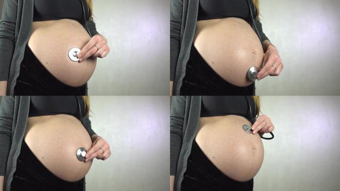 年轻孕妇用听诊器听自己的肚子。