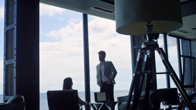 商业团队剪影在海云景观中交谈。两名经理工作笔记本电脑