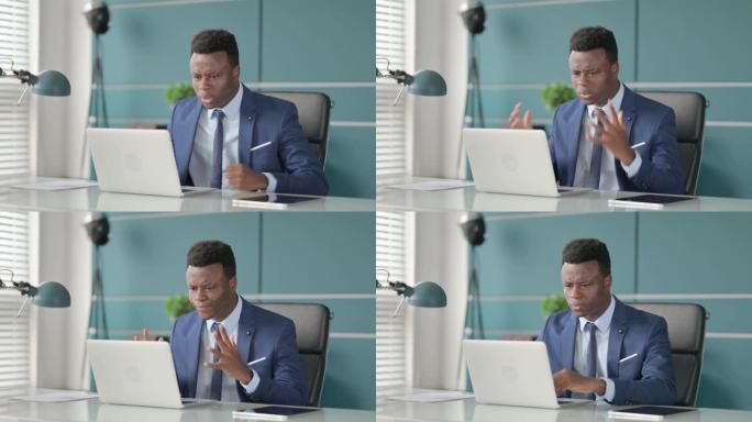 愤怒的非洲男子在使用笔记本电脑时吵架