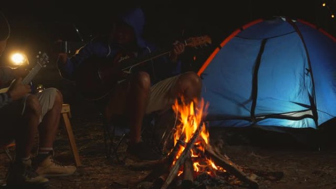 两个男人在夜间露营时玩得开心