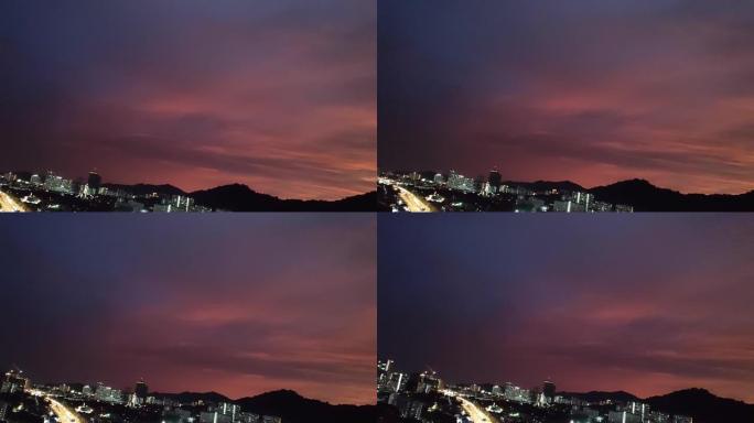 粉色-紫色-橙色像日落多云的天空，有山、高速公路、车辆和城市景观-暗景
