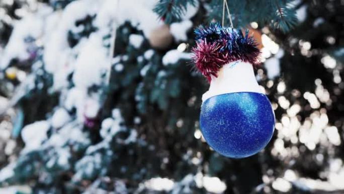 被雪覆盖的圣诞树上的蓝色球。